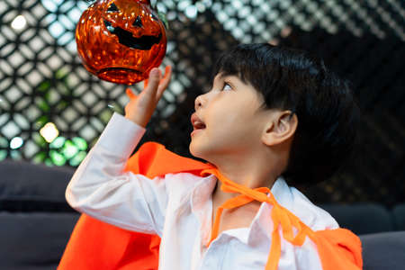 Side view - Asian boy playing with pumpkin halloween in the party.の写真素材