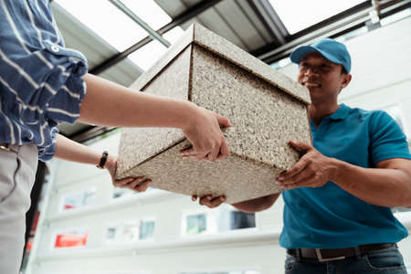 A man carrying package to customer with smile on his face - courier service concept.