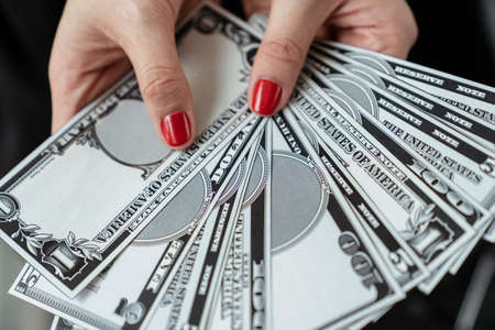 Hands of rich successful woman holding banknote cash currency money.