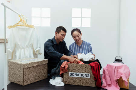 Two asian people making charity cloth donation box for homeless kids.の写真素材