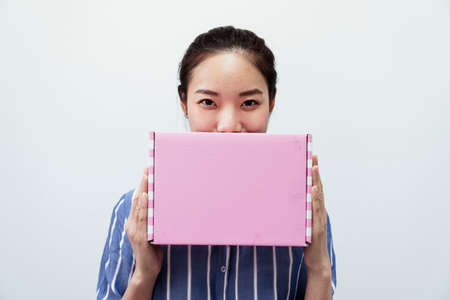 Joyful asian thai woman with pink gift box isolated on white background. Beauty and fashion.の写真素材