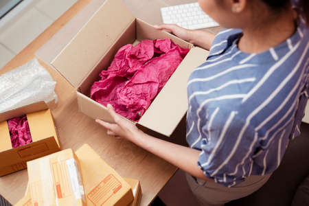 delivery, shipping, order, shipment, shopping, female, box, purchase, home, opening, happy, woman, person, young, cardboard, carton, people, container, postal, receive, parcel, package, pack, beautiful, packaging, post, service, unpacking, girl, smiling, apartment, holding, lifestyle, gift, retail, room, living, pretty, cheerful, cargo, sale, pink, red, cloth, table, thai, asia, asian, ethnicity, packingの写真素材