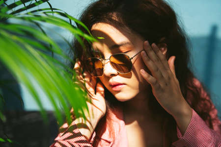 Close up portrait of asian woman wearing sunglasses at park.の写真素材