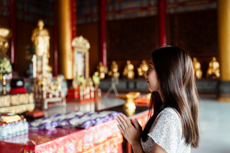 Thai woman praying in the temple. Asian woman paying respect to Buddha statue in Thailand.の写真素材