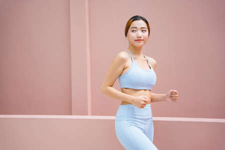 Beautiful sporty asian woman wearing sport bra with running pose.の写真素材