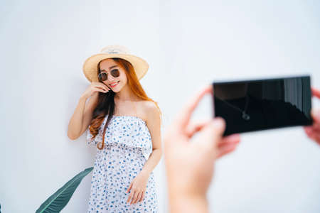 Beautiful asian traveler woman being take photo with smartphone.の写真素材