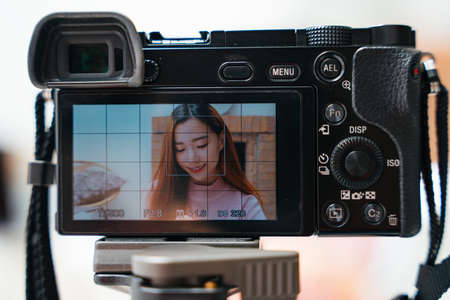 Beautiful asian woman filming cosmetic testing show with camera video.の写真素材
