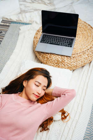 Top view - Beautiful young asian woman wearing pink sweater sleeping on pillow. Autumn vibe.の写真素材