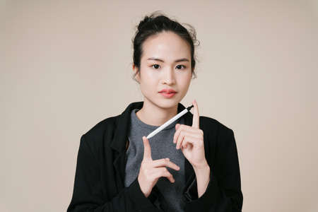 Portrait of asian business woman wear black jacket isolate on beige background.の写真素材
