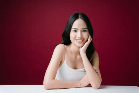 Beautiful young asian woman black hair with natural make-up skincare isolated on red background.の写真素材
