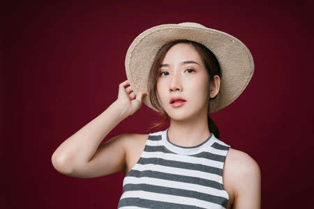 Portrait of beautiful young asian woman wearing hat isolate on red background.
