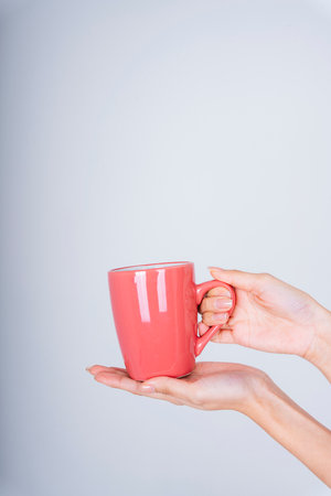 Woman hand holding mock up coffee cup isolate on white background.
