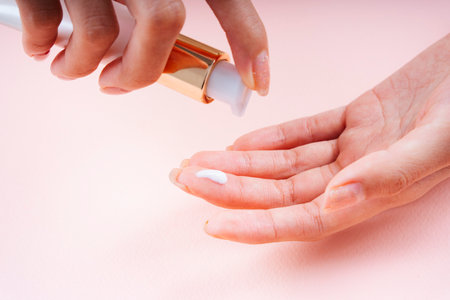 Hand of woman applying cream lotion on hands.