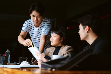 Three young business people working together on start up project in meeting room.の写真素材