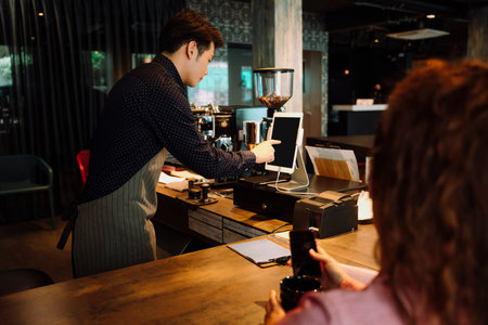 Bartender making food and berverage bill in digital tablet in cafe.