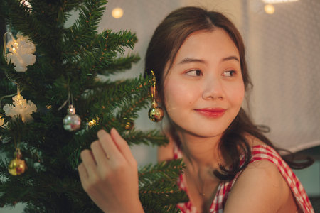 Beauty young asian woman black hair decorating christmas tree in party.の写真素材