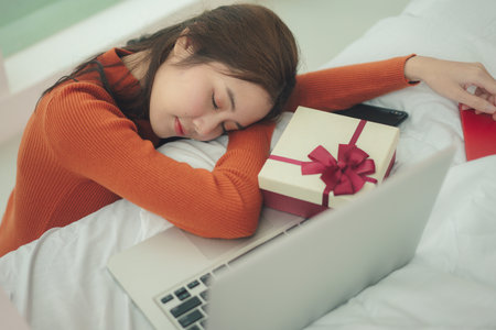 Beauty young asian woman black hair sleeping infront of laptop in christmas day.の写真素材