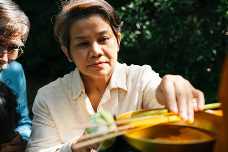 Senior elder woman giving alms offering to monk in the morning.の写真素材
