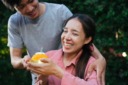 Asian man surprise girlfriend with birthday cake made of golden thread dessert.の写真素材