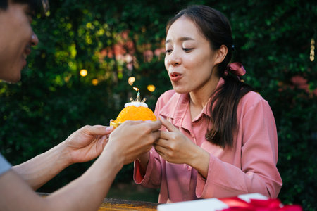 Asian woman celebrate birthday party with golden thread dessert cake with boyfriend.の写真素材