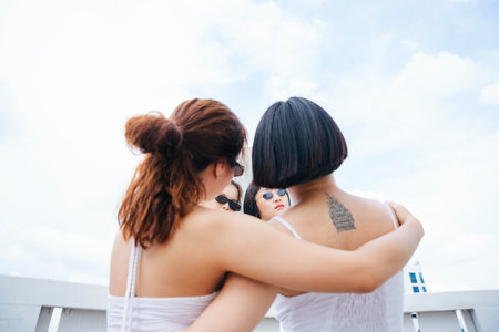 Back view - Portrait of two young asian women hugging each other.の写真素材