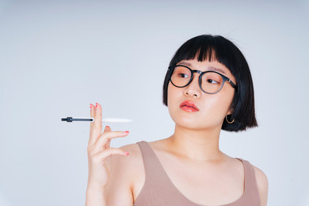 Portrait of young asian woman short bob hairstyle wearing sunglasses holding pen isolate on white background.の写真素材