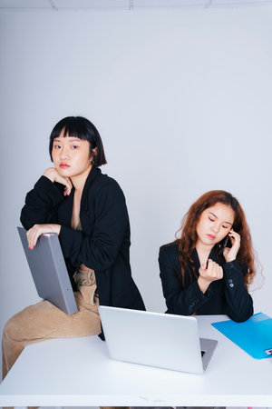 Portrait of two young business asian women wearing formal jacket suit working together in office.の写真素材