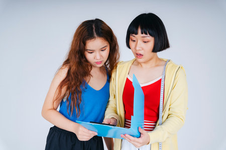 Gym coach and member looking at BMI document paper isolate on white background.の写真素材