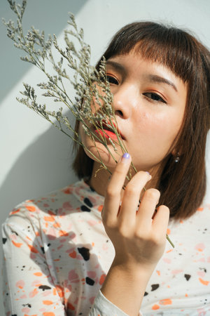 Beautiful woman short hair asian holding palea plant over white background.の写真素材