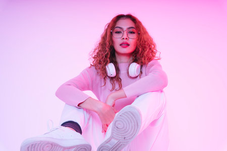 Asian young beauty girl curly hair with wireless headphone in neon studio.