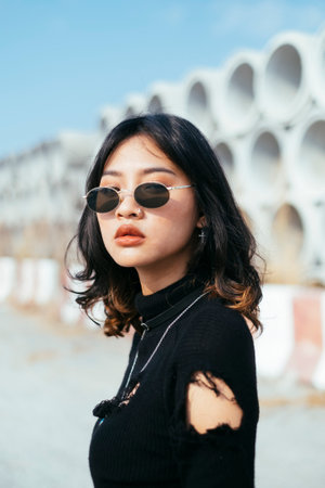 Medium close up portrait shot of fashionista girl in black sweater and sunglasses.の写真素材