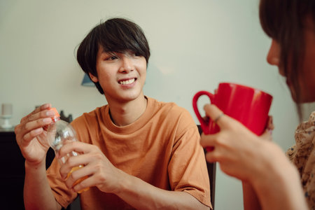 Asian thai couple drinking water together at dinning room. Eat food with lover.の写真素材
