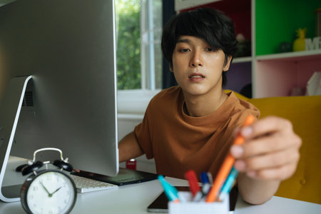 Asian businessman working at home with laptop. Covid-19 outbreak period.の写真素材