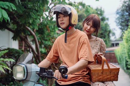 Asian thai couple riding on classic vintage motor bike. They go shopping at local market.