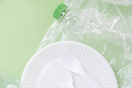 Top view - Plastic waste rubbish over green background.