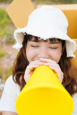 Young asian thai woman hipster curly hairstyle on white dress and hat speaking with yellow toy...