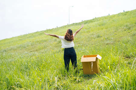 Young asian thai woman hipster curly hairstyle on white shirt standing outside of the box on slope...
