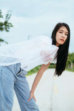 Portrait of young asian thai long dark hair woman bride with white veil outdoors.の写真素材