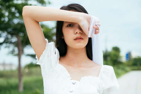 Closed up - Portrait of young asian long dark hair woman bride with white veil outdoors.の写真素材