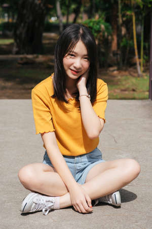 Black long hair gir standing and sitting on the bridge in the park in sunny day.