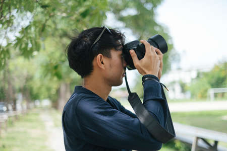 Male photographer take a photo of leaf, tree and sky.の写真素材