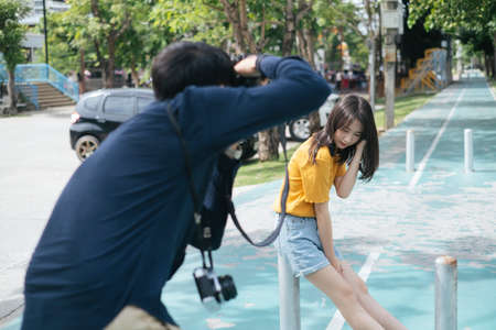 Male photographer and teenage femal model take a photo on the bicycle lane.