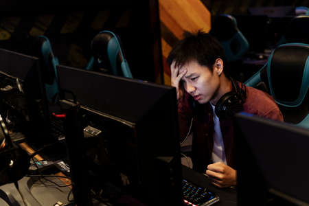 Young asian gamer facepalm at computer after seeing something weird on the internet.の写真素材