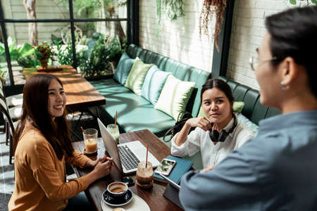 Happy young business women listen to their boss and smile.