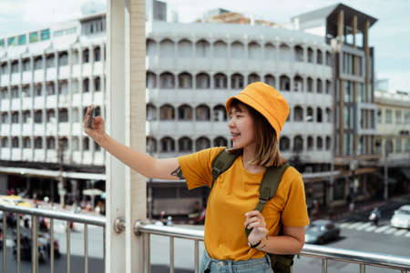 Backpacker girl take a selfie on a skywalk on the junction with her smiling face.の写真素材