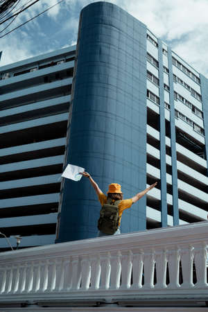 Backpacker girl raise her hands with a map up to the sky like a freedom.の写真素材