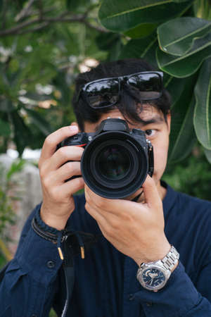 Male camera shooting under the plumeria tree.の写真素材