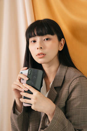 Young businss beautiful asian thai long dark hair woman wearing suit jacket with many mobile phone.の写真素材