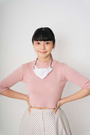 Fashion portrait - Beautiful asian thai long dark hair woman in pink shirt with white surgery mask isolate over white background.の写真素材