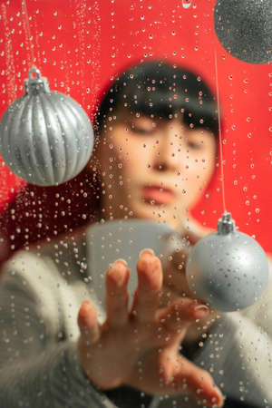 Fashion portrait - Beautiful asian thai long dark hair woman with cup of coffee in rain season. Raining dayの写真素材